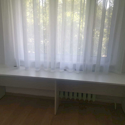 Белый двухместный стол вдоль окна